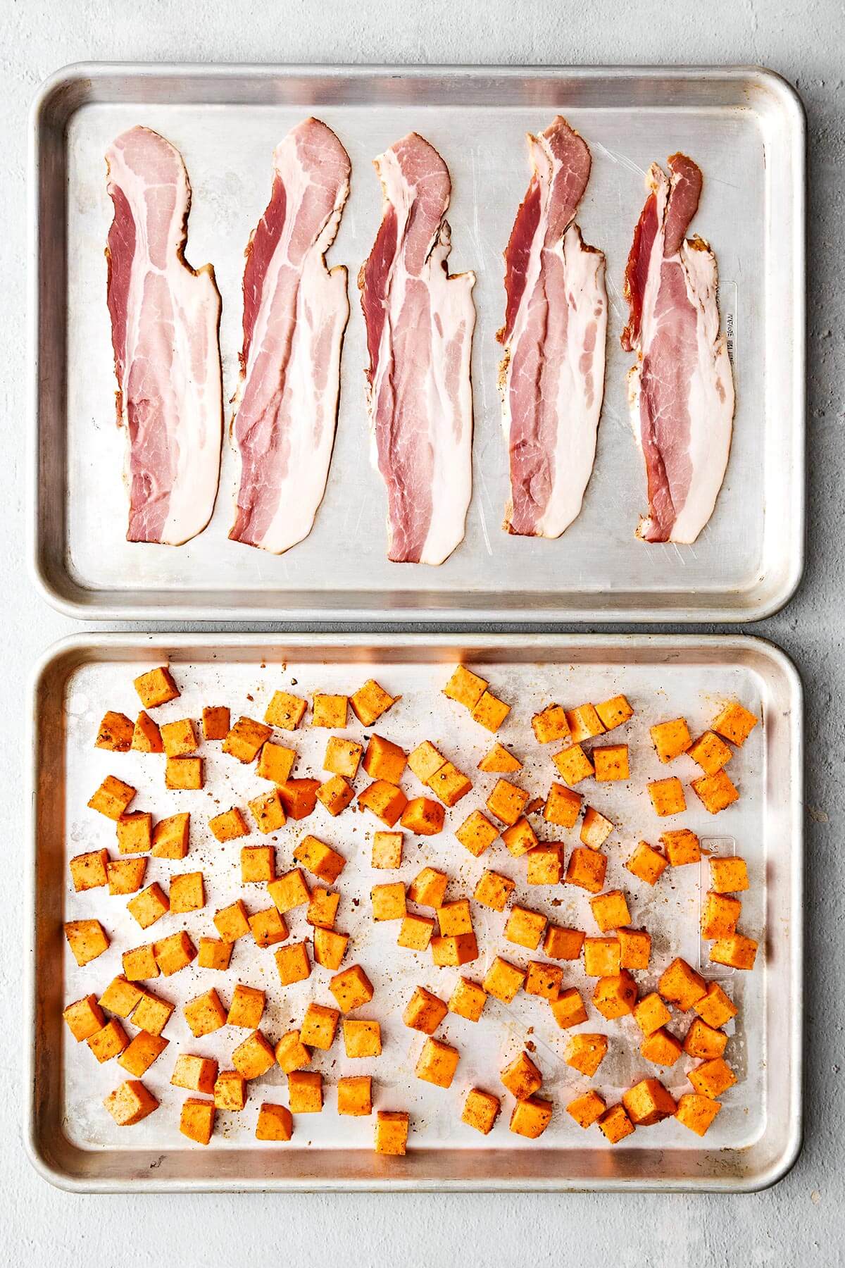 This is the best breakfast casserole loaded with bacon, sausage, sweet potatoes, and plenty of veggies. Plus, it's always a crowd favorite! Bacon and sweet potatoes on a sheet pan.