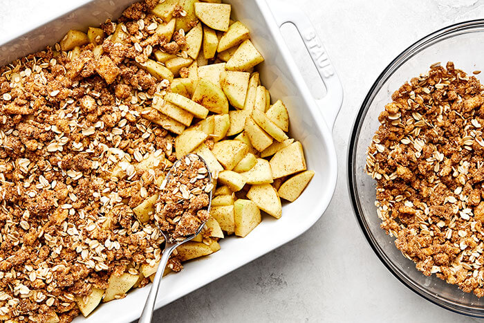 Assembling apple crisp in a casserole dish.