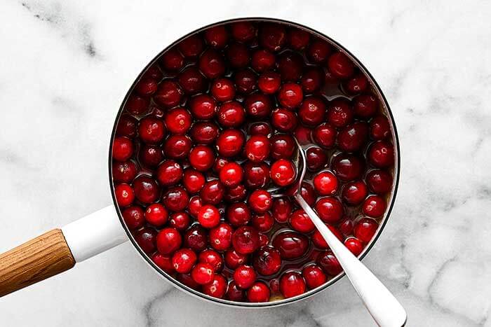 Boiling cranberries in a pot.