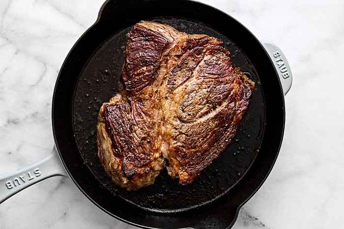 Seared steak in pan.