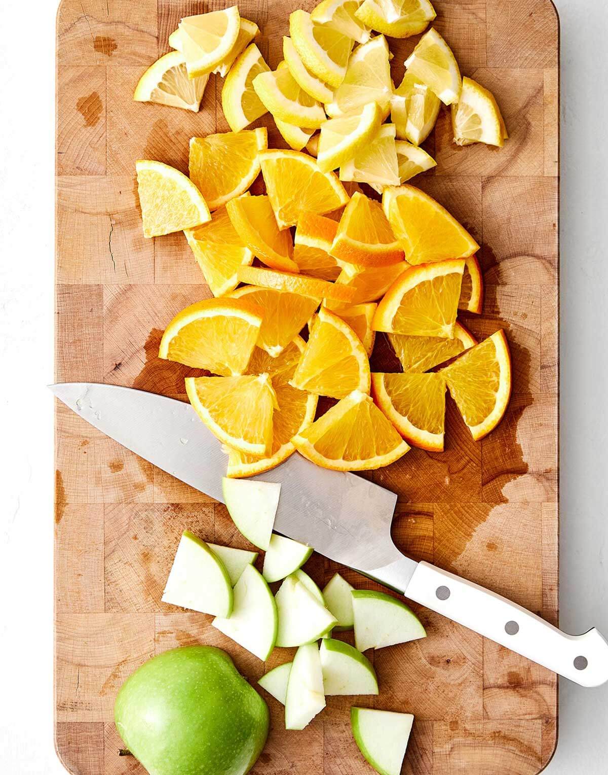 A pitcher of this red sangria feels is the perfect cocktail for a crowd! All you need is Spanish red wine, brandy, and fresh fruit. Chopped fruit on a wooden board.
