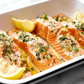 A white tray of lemon garlic baked salmon.