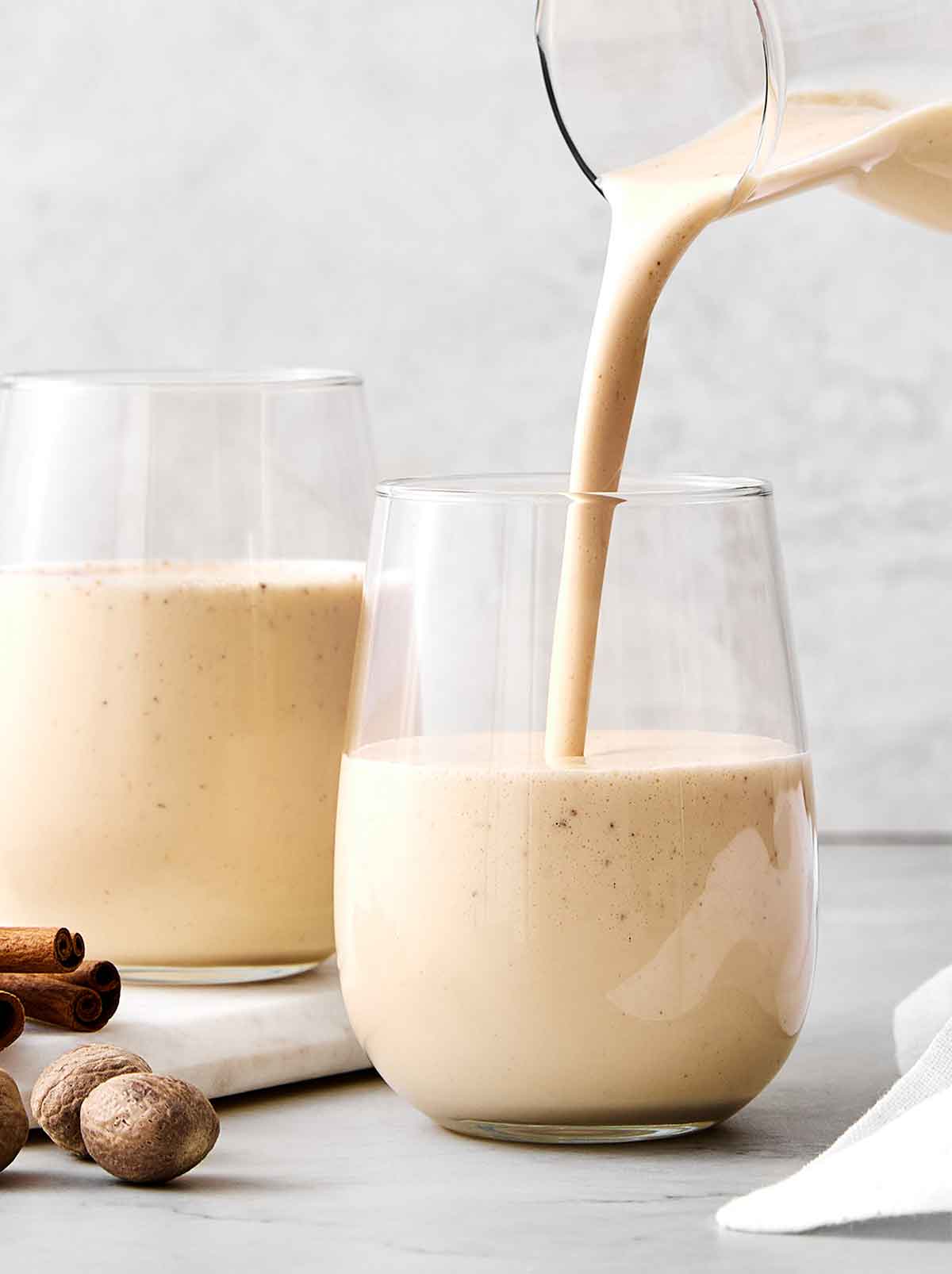 Pouring eggnog into a glass.