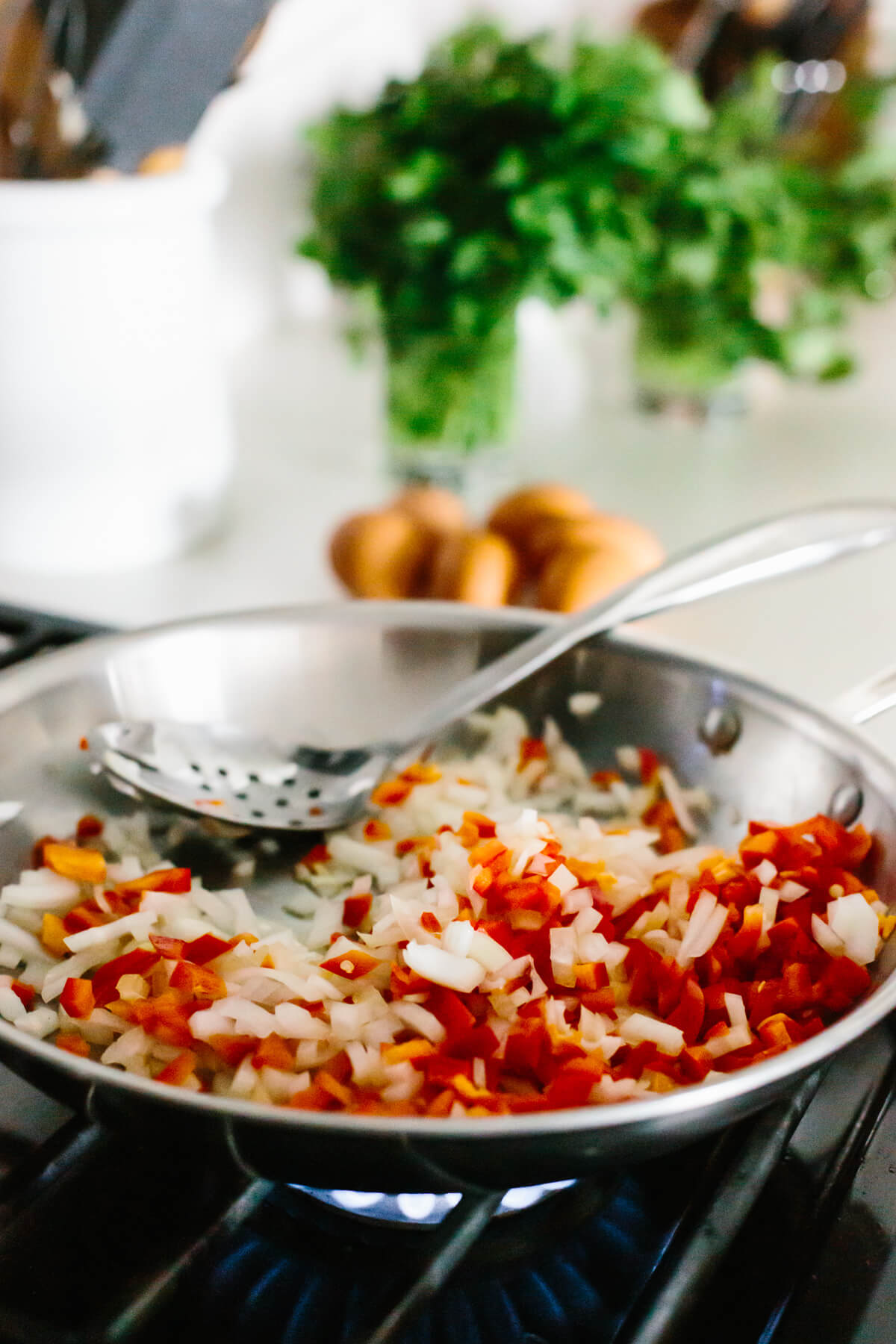 Sauteing onion and bell pepper in a pan.