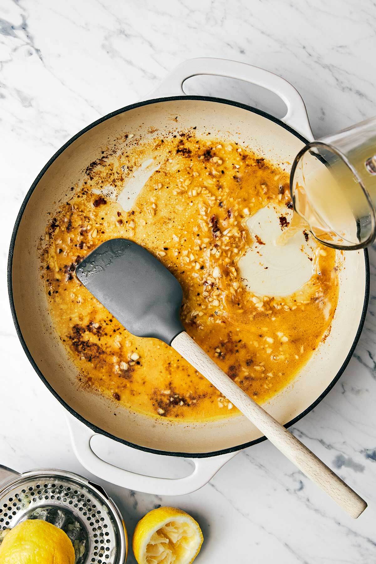 This lemon pepper chicken dinner is perfect for busy weeknights. It's bright and tangy with a golden crust and topped with a garlic butter sauce. Making garlic butter sauce in a pan.