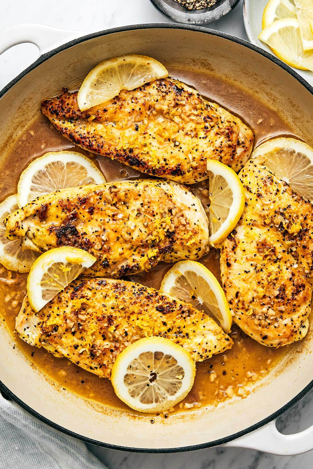 This lemon pepper chicken dinner is perfect for busy weeknights. It's bright and tangy with a golden crust and topped with a garlic butter sauce. Lemon pepper chicken in a pan.