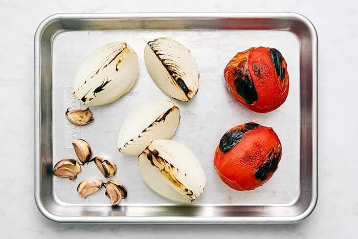 Roasting tomatoes and onions on a sheet pan.