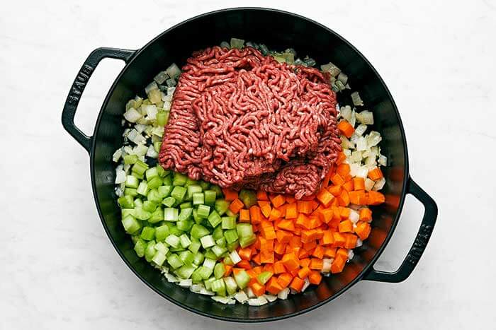 Cooking veggies and meat in a skillet.