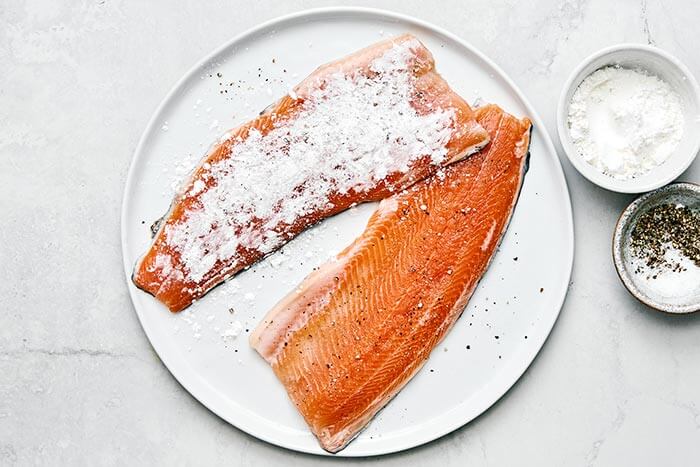 Coating rainbow trout with flour.