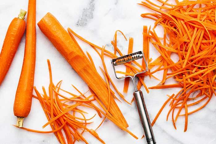 Julienning carrots with a peeler.