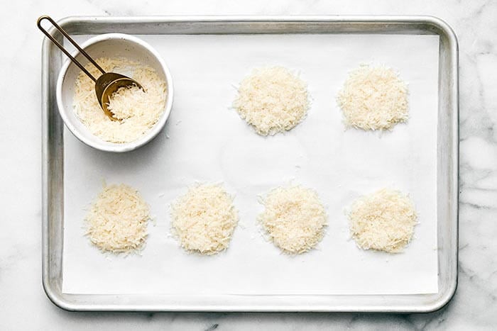 Prepping parmesan for crisps on a baking sheet.