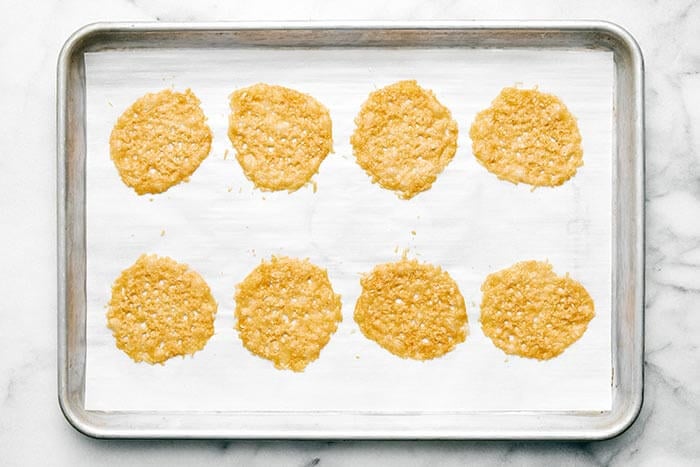 Baked parmesan crisps on parchment paper.