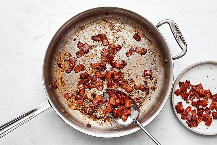 Cooking bacon bits in a pan.