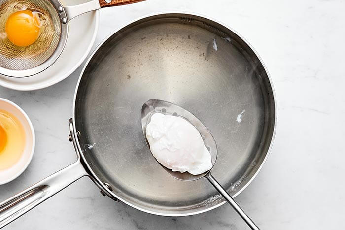 Cooking a poached egg in a pot.