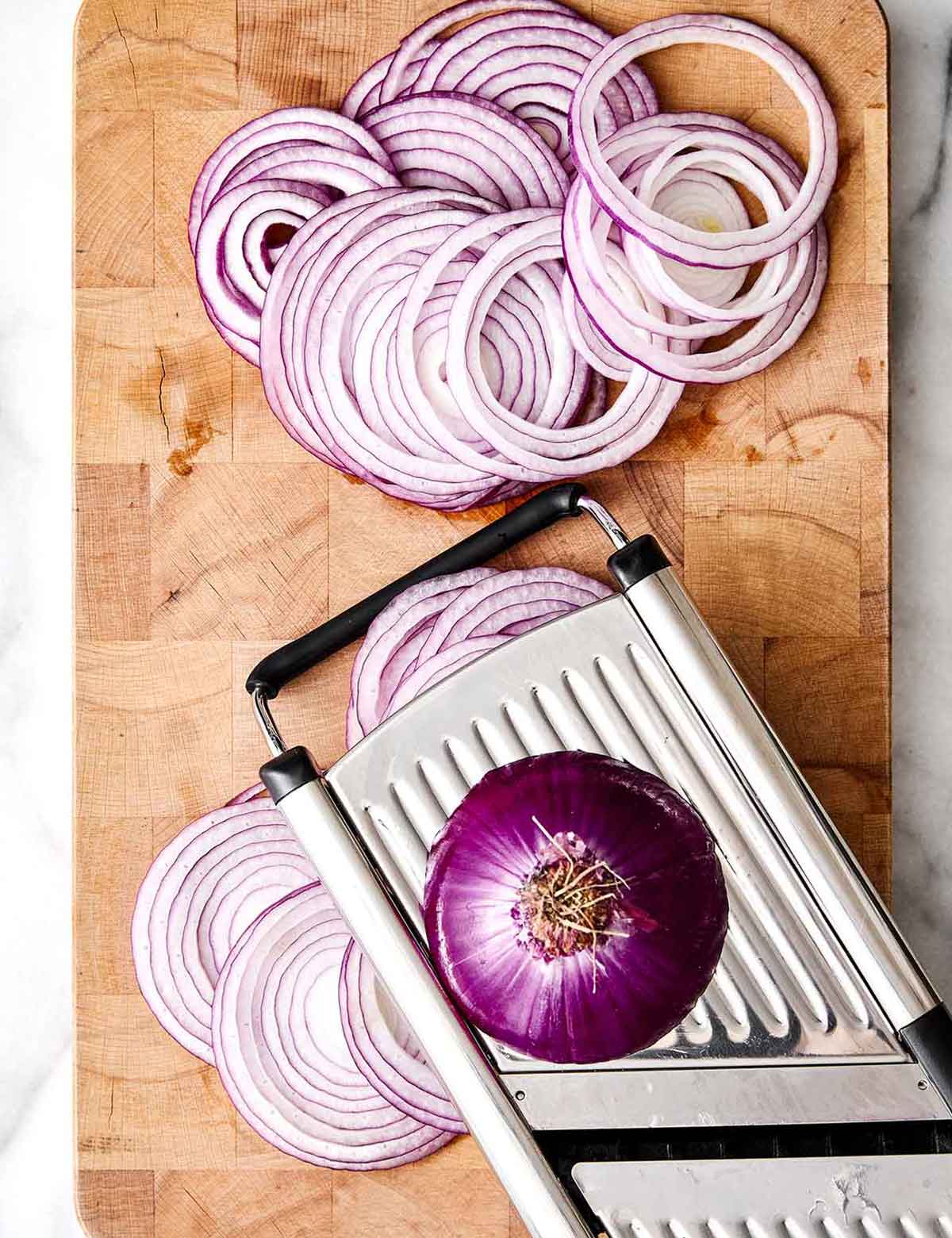 A jar of these pickled red onions is one of the easiest ways to instantly upgrade a meal! They’re tangy, slightly sweet, and extra punchy. Slicing red onions with a mandoline.