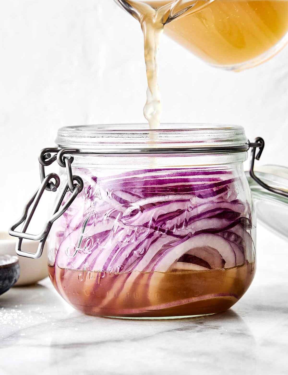 A jar of these pickled red onions is one of the easiest ways to instantly upgrade a meal! They’re tangy, slightly sweet, and extra punchy. Making quick pickled onions in a jar.