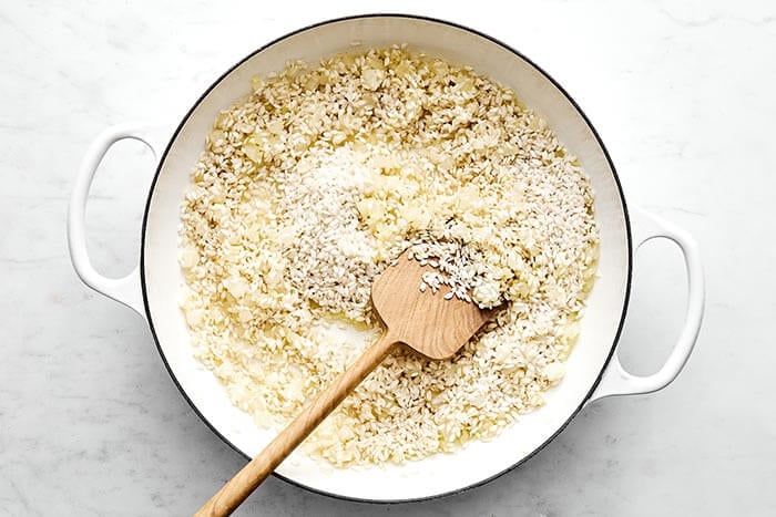 Cooked rice and aromatics in a pan.