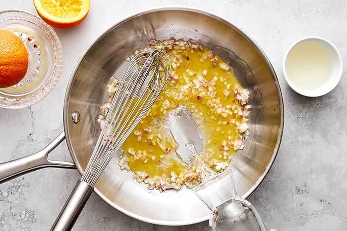 Cooking shallots and wine in a pan.