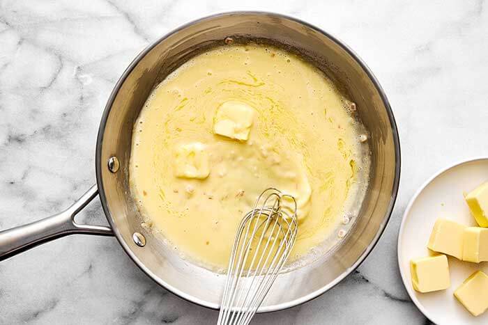 Cooking beurre blanc in a pan.