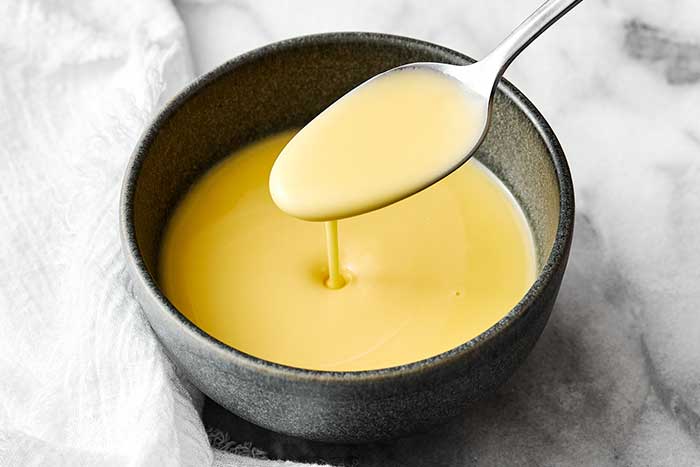 A bowl of beurre blanc with a spoon.