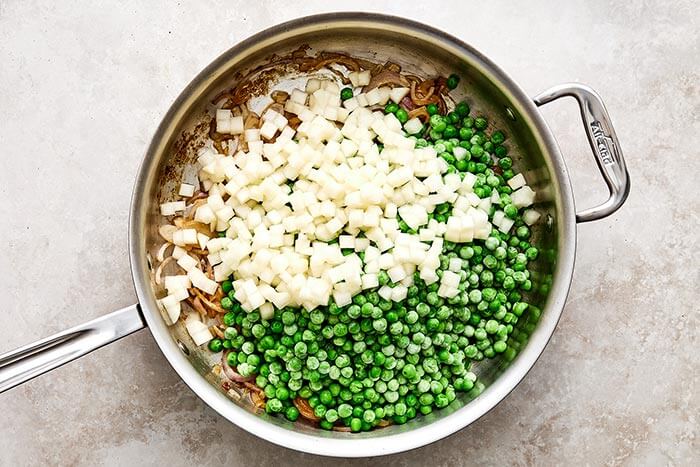 Cooked peas and pears in a pan.