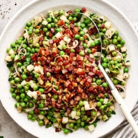 A white bowl of Thanksgiving peas side dish.