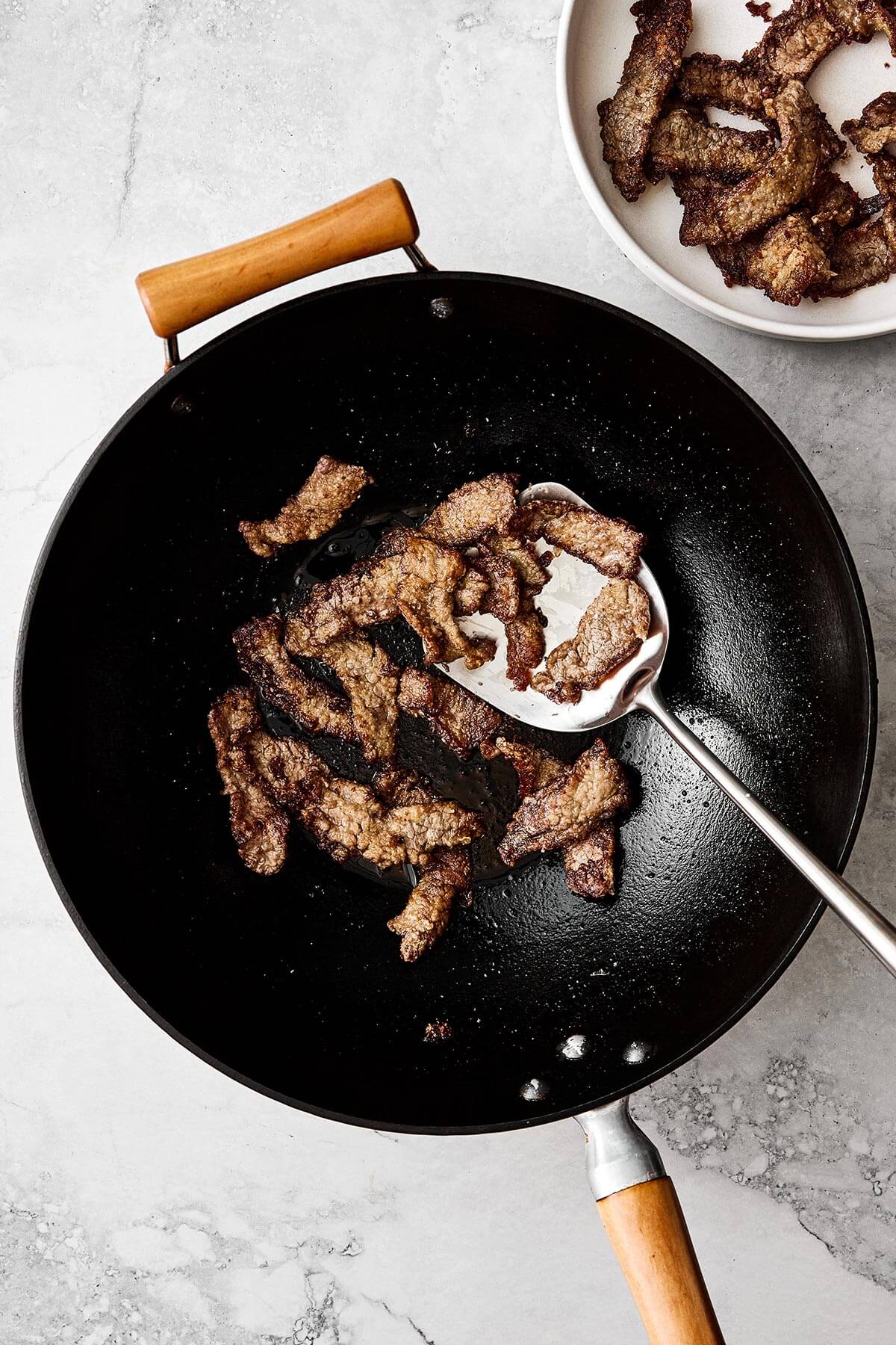Cooking flank steak in a wok.
