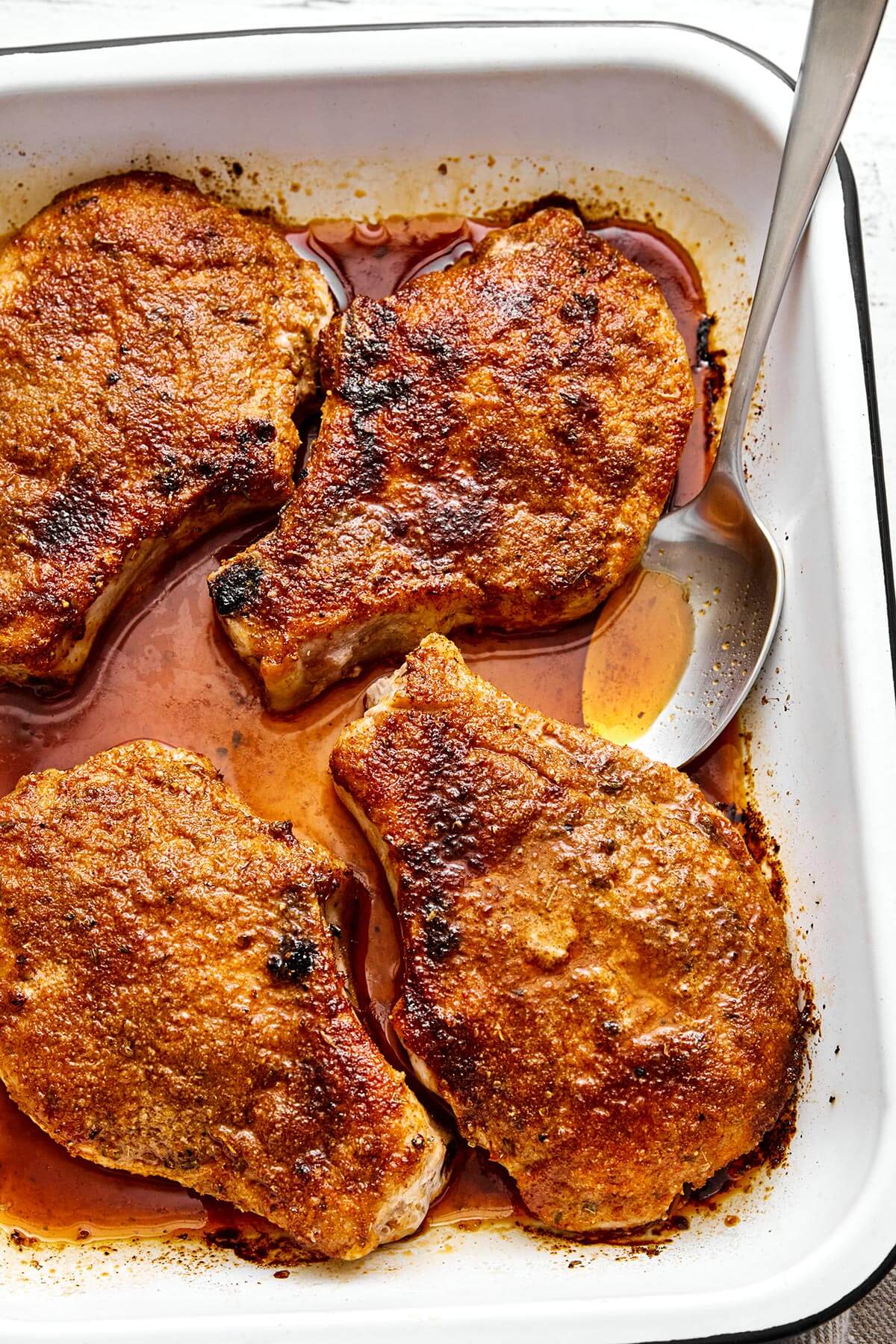 Baked pork chops in a baking dish.