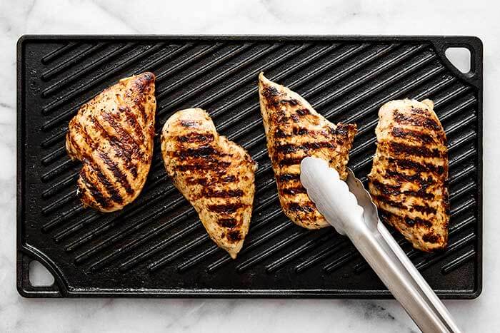 A griddle with grilled chicken.