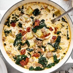 A white pot of Zuppa Toscana soup.