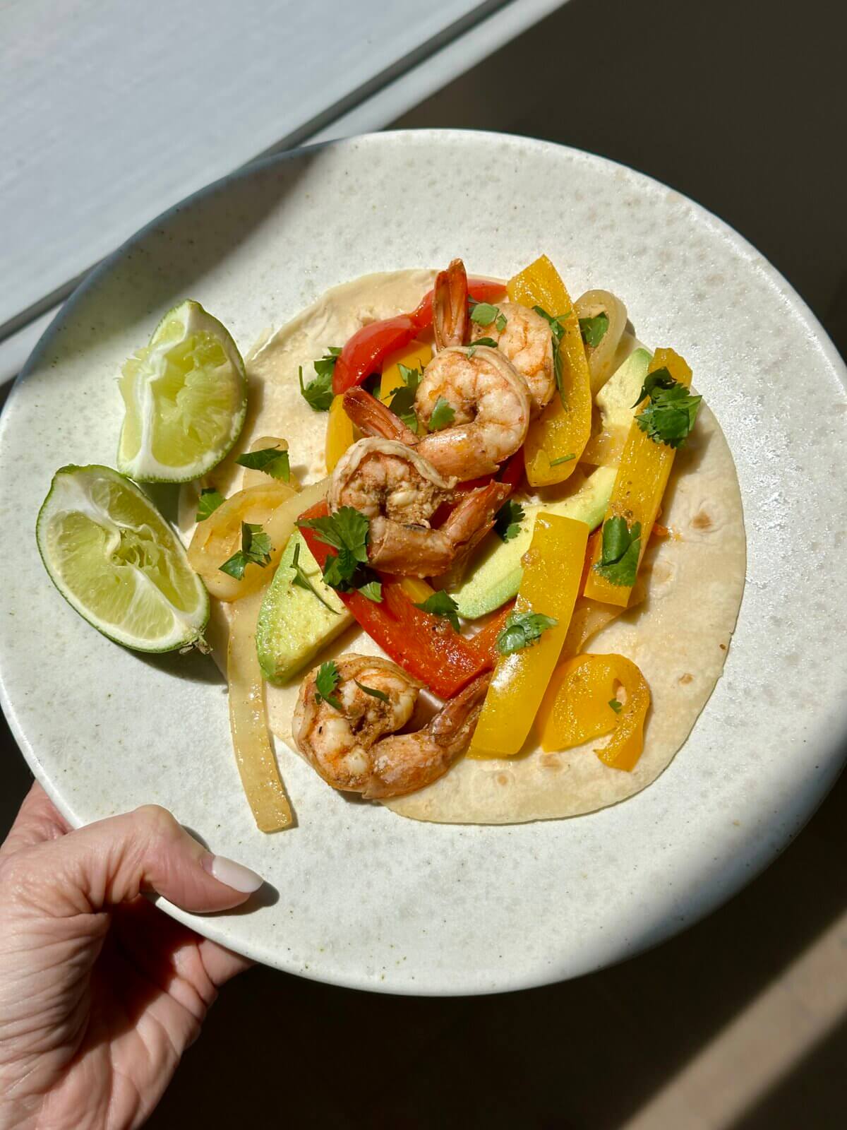 A serving of shrimp fajitas on a plate.