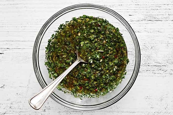 A bowl of chimichurri sauce.