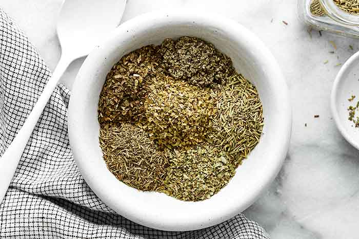 Italian seasoning ingredients in a white bowl.