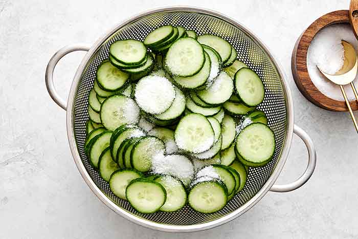 Prepping cucumber slices in a colander.