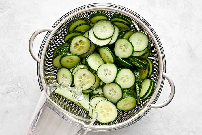 Rinsed cucumber slices in a colander.