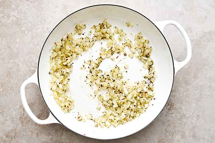 Cooked aromatics in a pan.