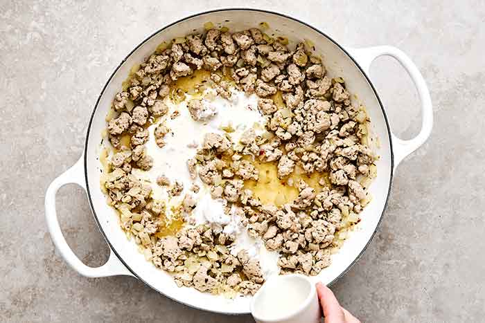 Cooking ground turkey with cream in pan.