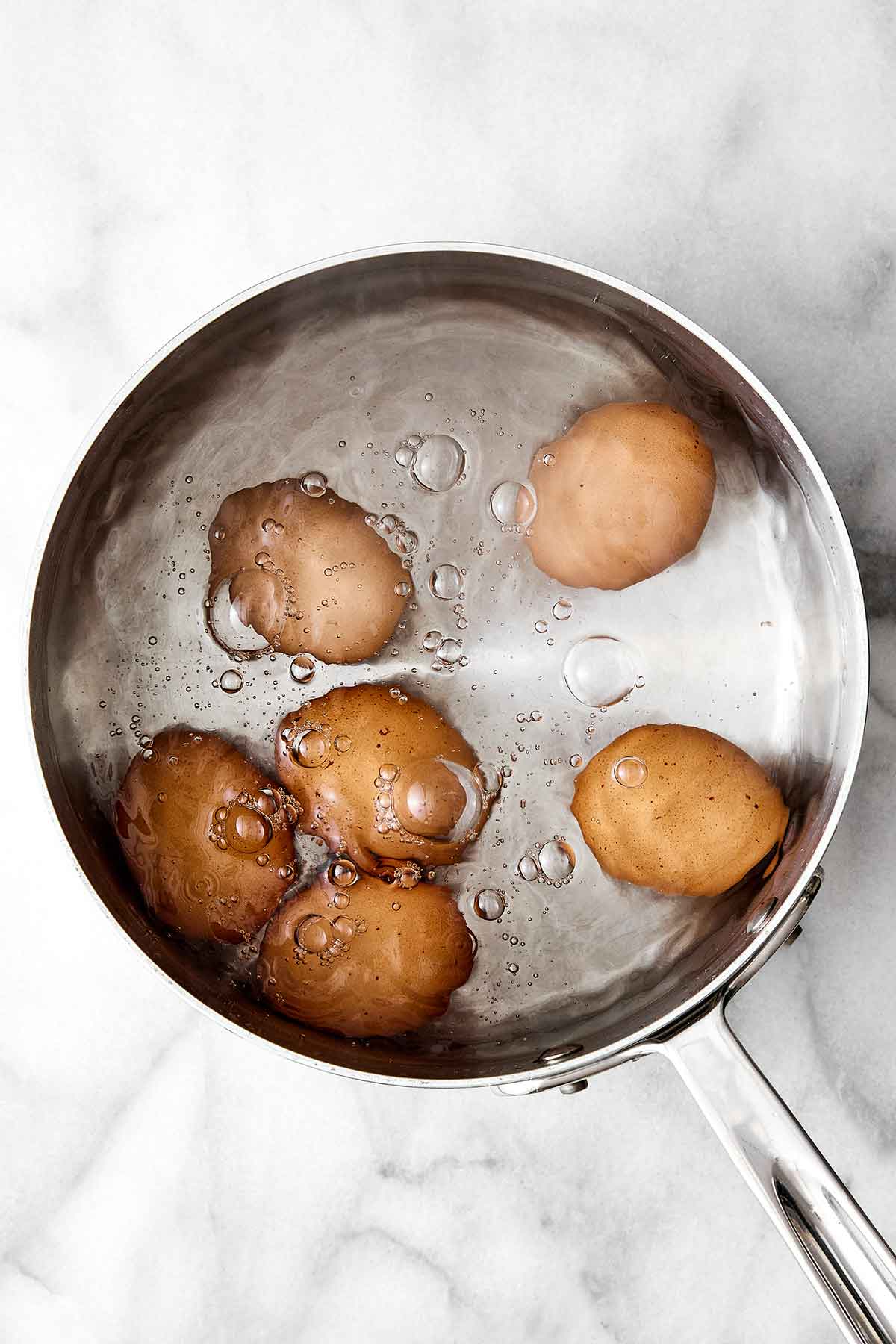 Eggs in boiling water in a pot.
