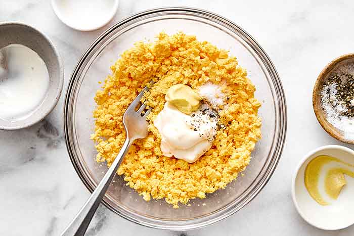 Mashing egg yolk for deviled eggs.