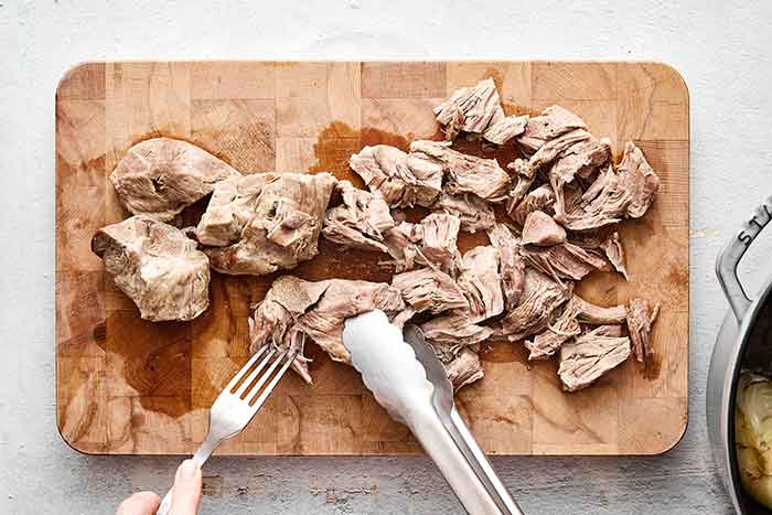 Shredded pork on a board.