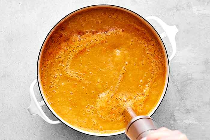 Step three of red lentil soup: add broth and lentils.