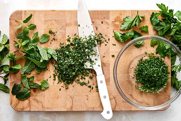 Step one of mint chimichurri: chop herbs.