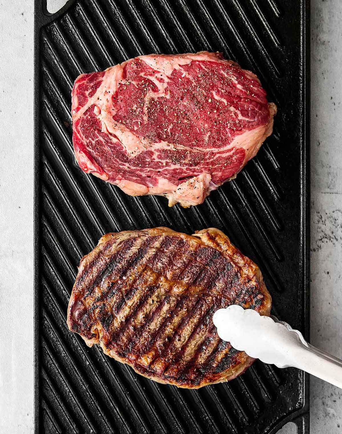 Grilling ribeye steaks on a grill pan.