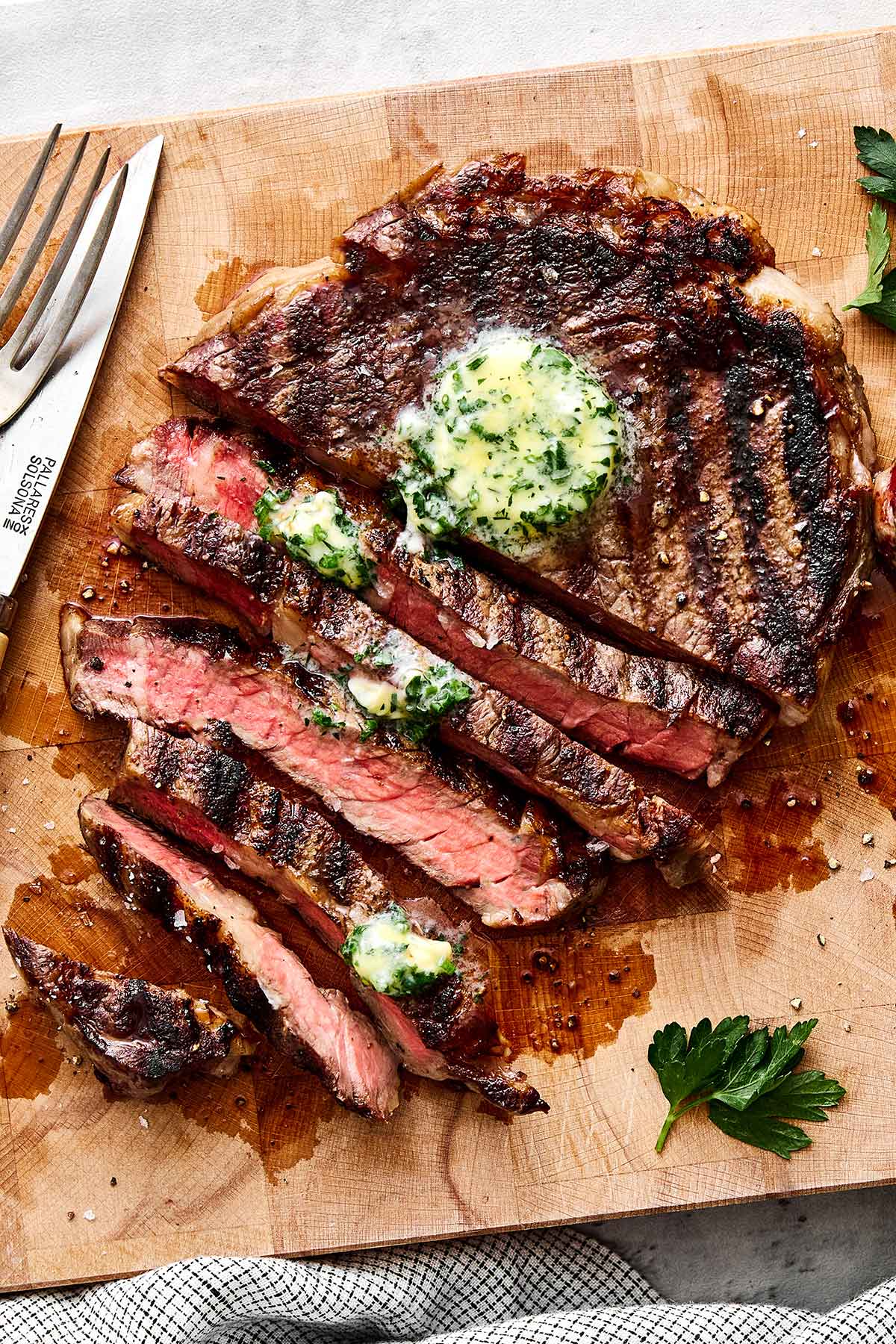 Grilled ribeye steak on a wooden board.