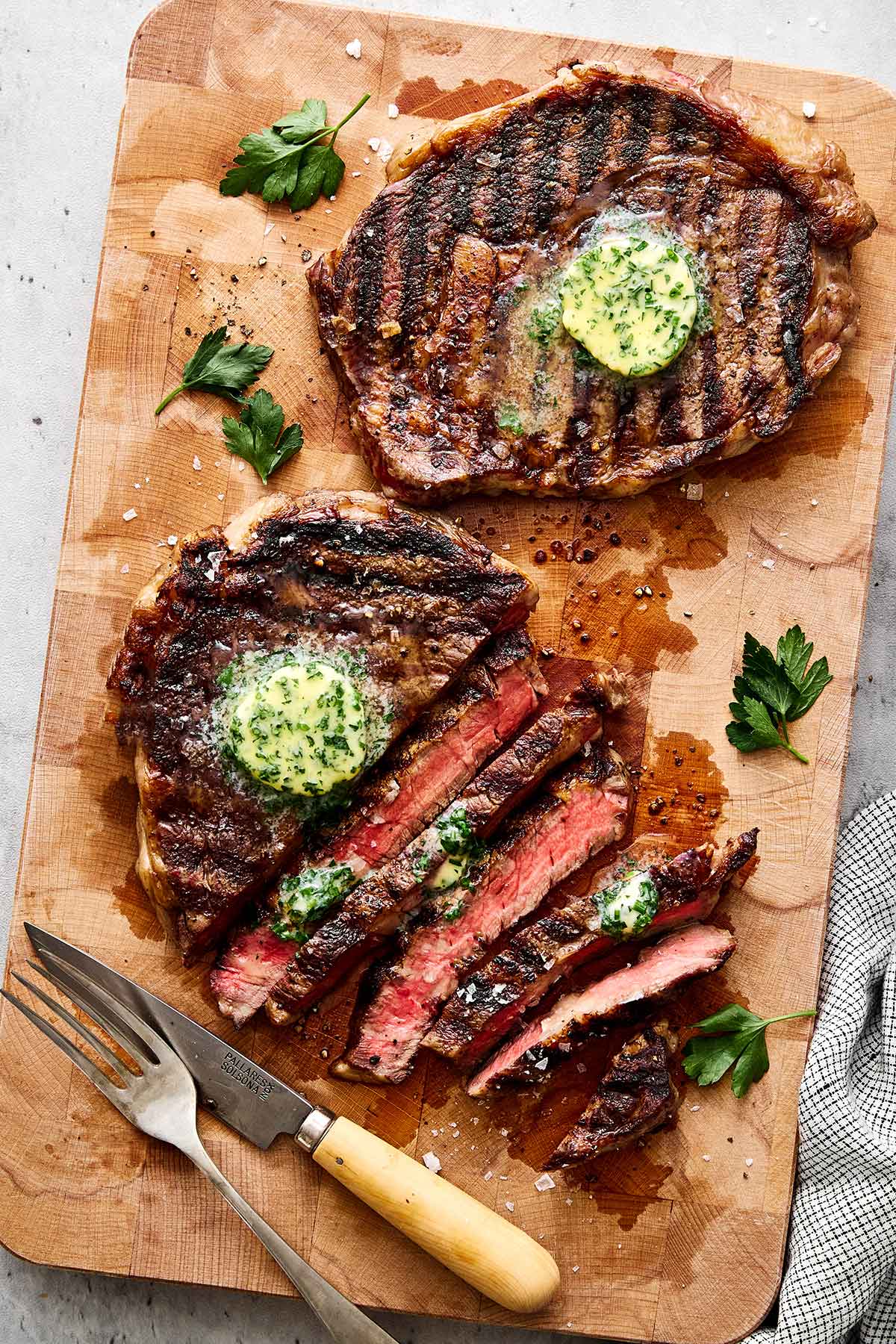 Grilled ribeye steaks with butter.