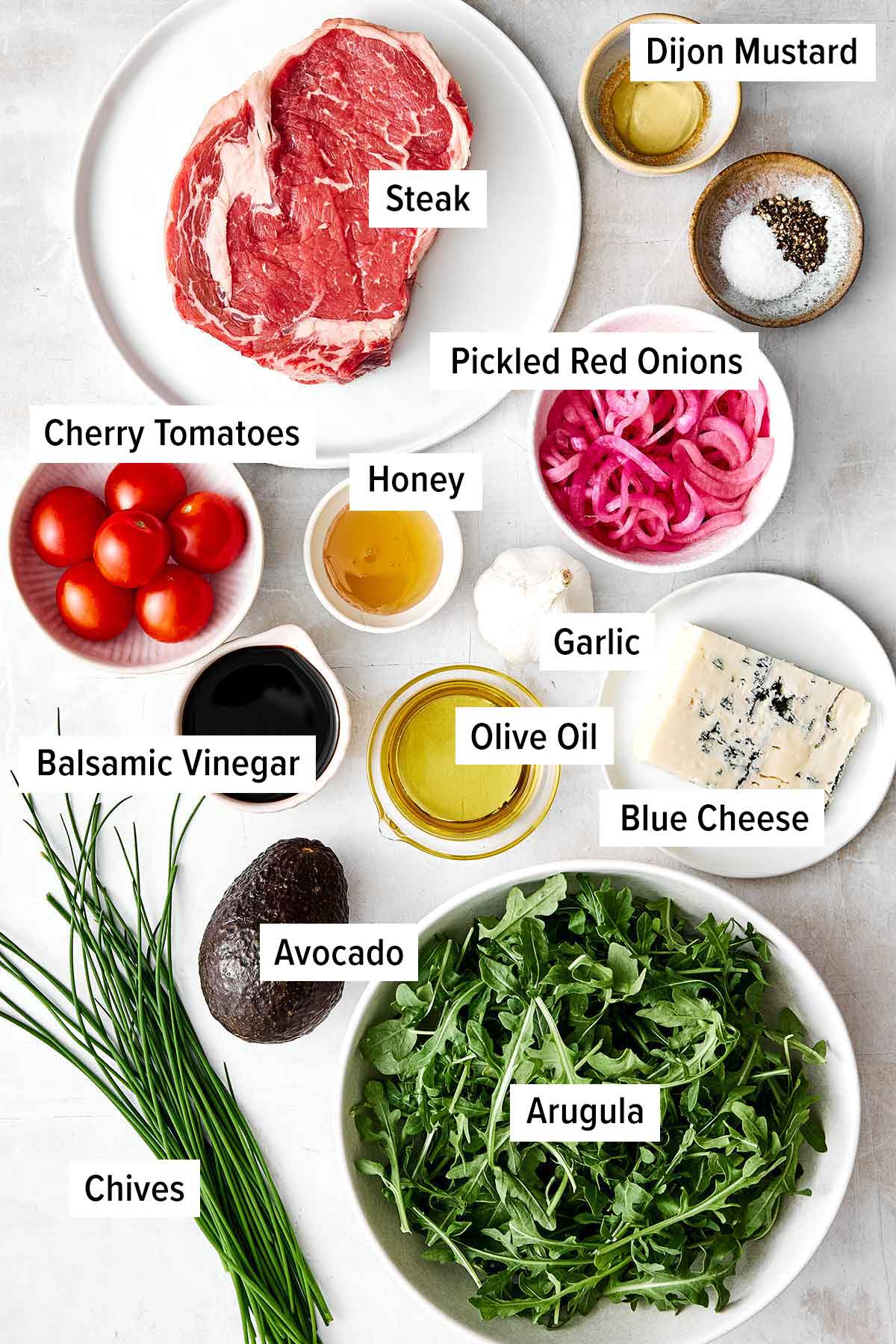 This steak salad piled high with grilled steak, arugula, fresh veggies, and a balsamic dressing is my favorite summer salad yet! Steak salad ingredients.