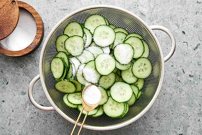 Salting cucumbers to make cucumber salad.